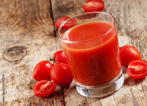 Fresh tomato juice and tomatoes on the table, selective focus