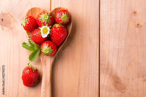 Food Hintergrund - Frische Erdbeeren auf Kochlöffel in Herzform photo