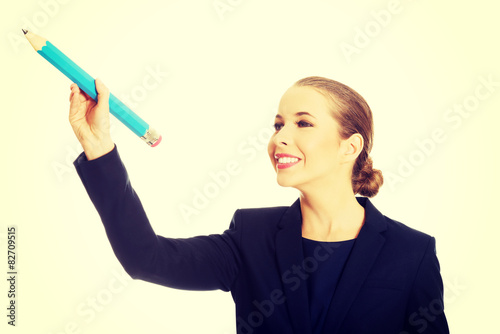 Businesswoman holding big pencil