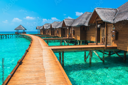 Over water bungalows with steps into amazing green lagoon photo