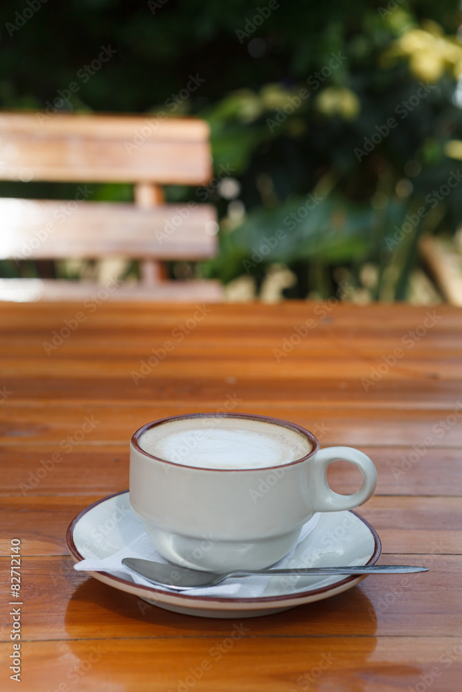 A cup of coffee latte on wood table