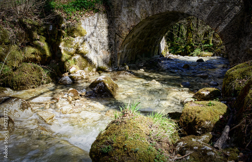 a small stream under a stone bridge