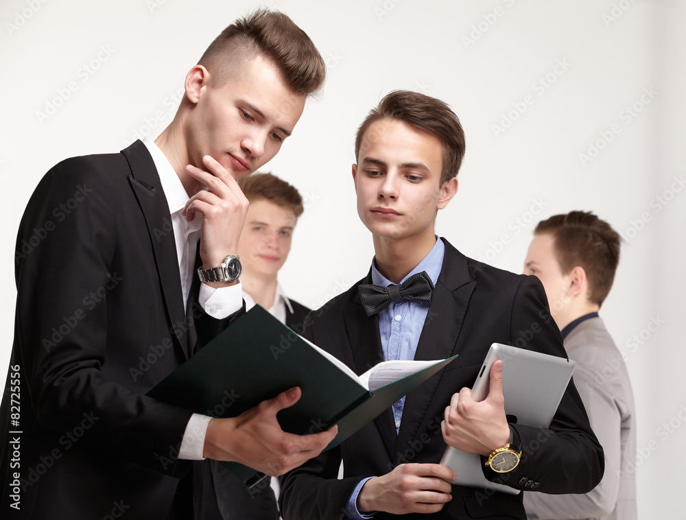 a group of young businessmen looking at paperwork a group of young businessmen looking at paperwork
