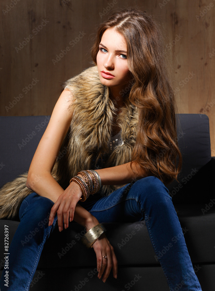 Portrait of a elegant woman sitting on a black sofa wearing a