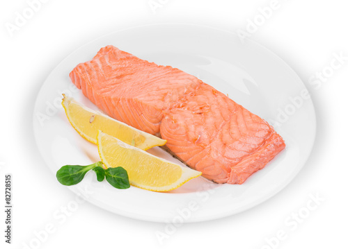 Fried salmon fillet on plate with lemon.