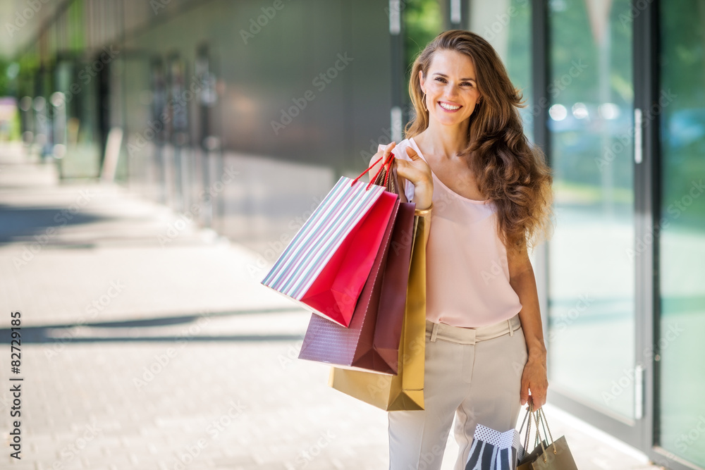 Smiling woman with shopping bags posing with colourful bags Smiling woman with shopping bags posing with colourful bags