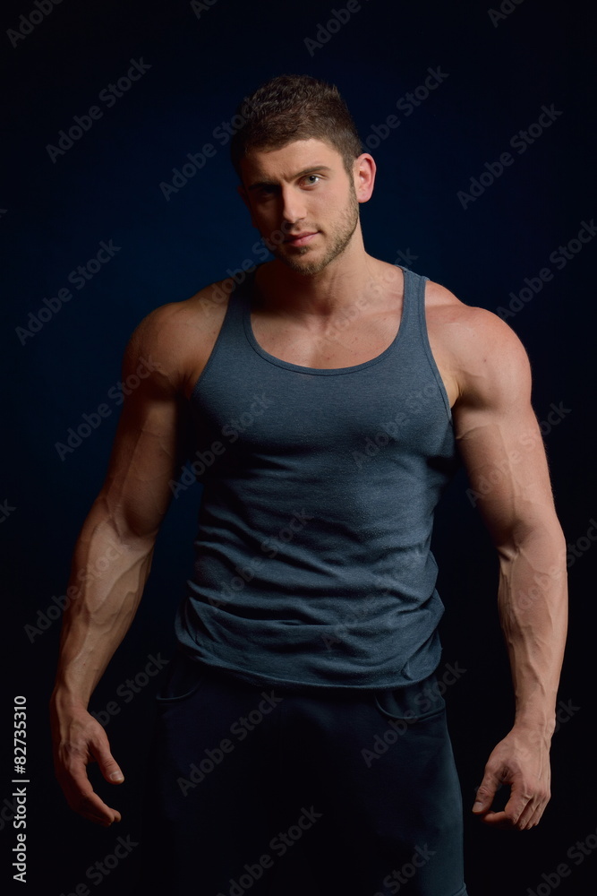 athletic young man portrait in studio with dark background athletic young man portrait in studio with dark background