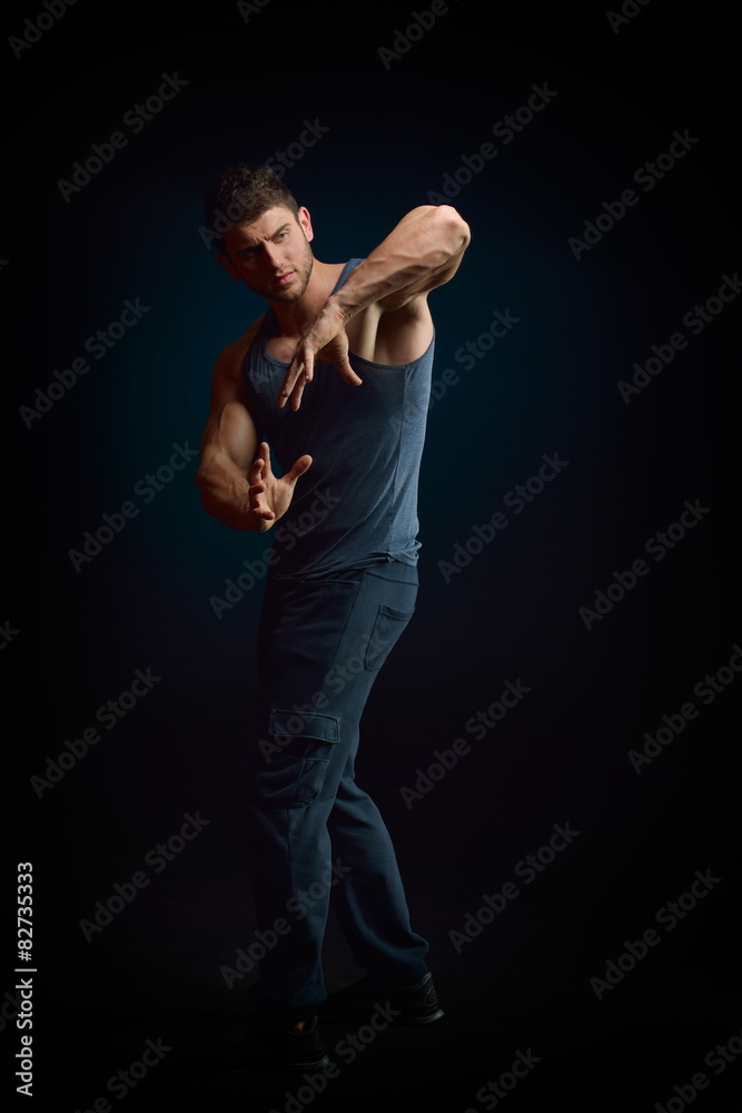 athletic young man portrait in studio with dark background
