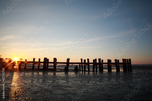 Holzsteg bei Ebbe und Sonnenaufgang