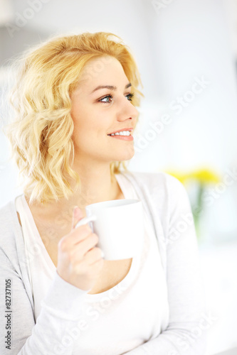 Young woman drinking coffee in the kitchen