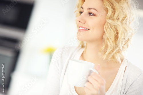 Young woman drinking coffee in the kitchen