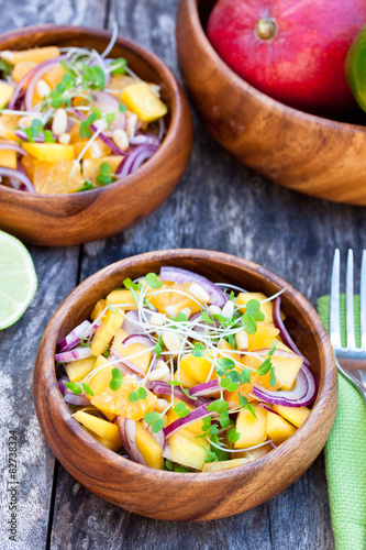 vegetarian salad with mango oranges and red onion on the wooden