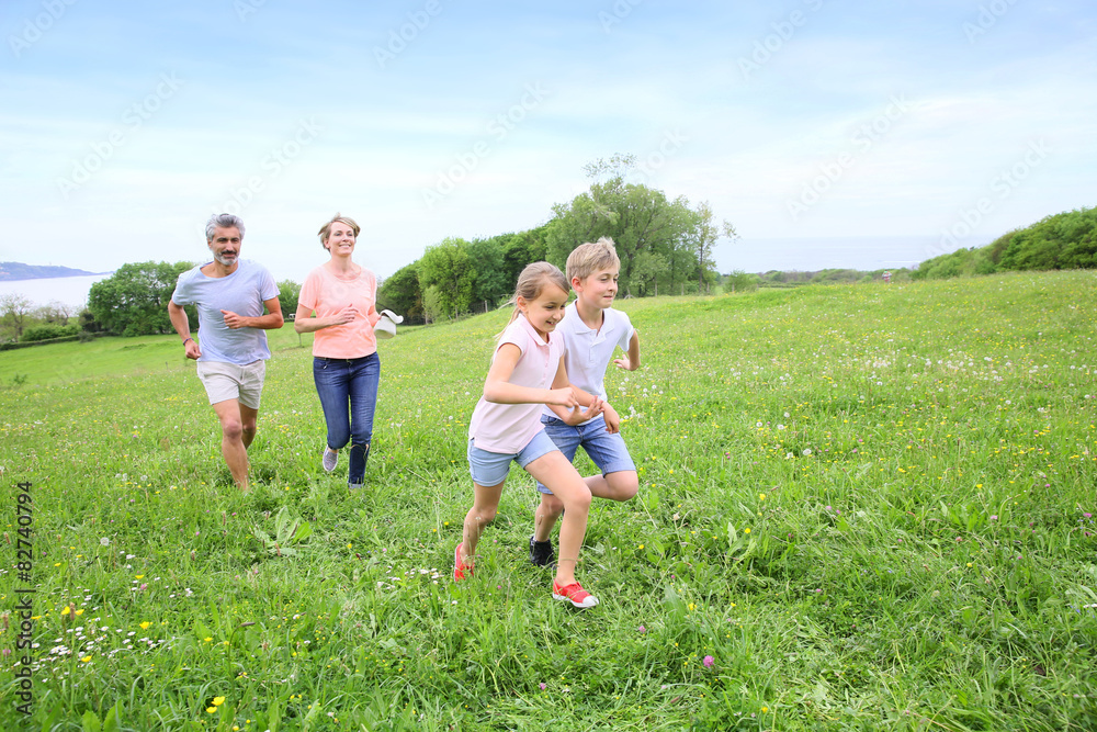 Family of four running in countryside