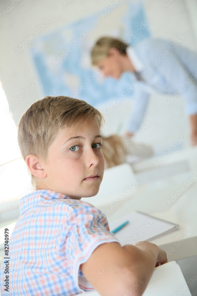 Young smiling schoolboy in classroom Young smiling schoolboy in classroom