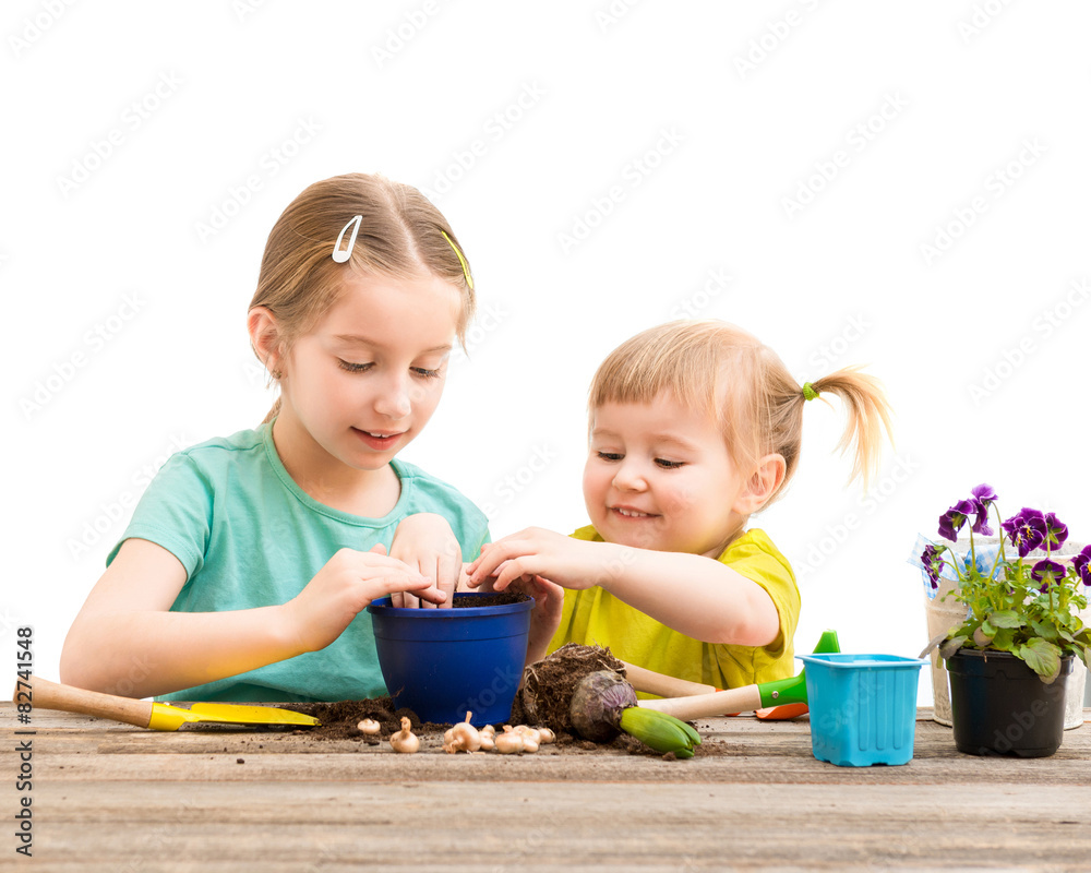 Two little sisters are engaged in gardening Two little sisters are engaged in gardening
