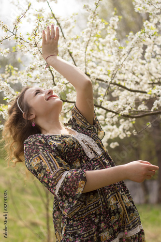 The joy of spring.  Happy girl near the blossoming apple tree. 