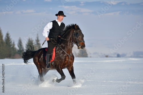 young man riding horse outdoor in winter