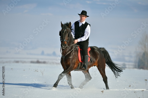 young man riding horse outdoor in winter