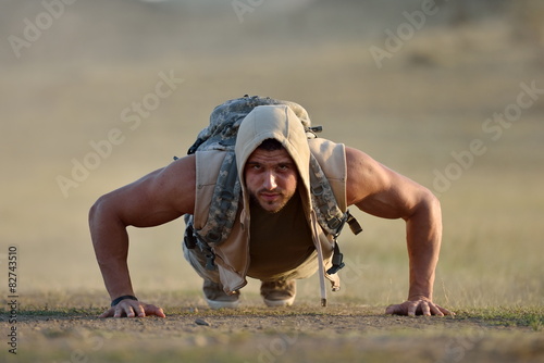 athletic young man exercising outdoor on dusty field