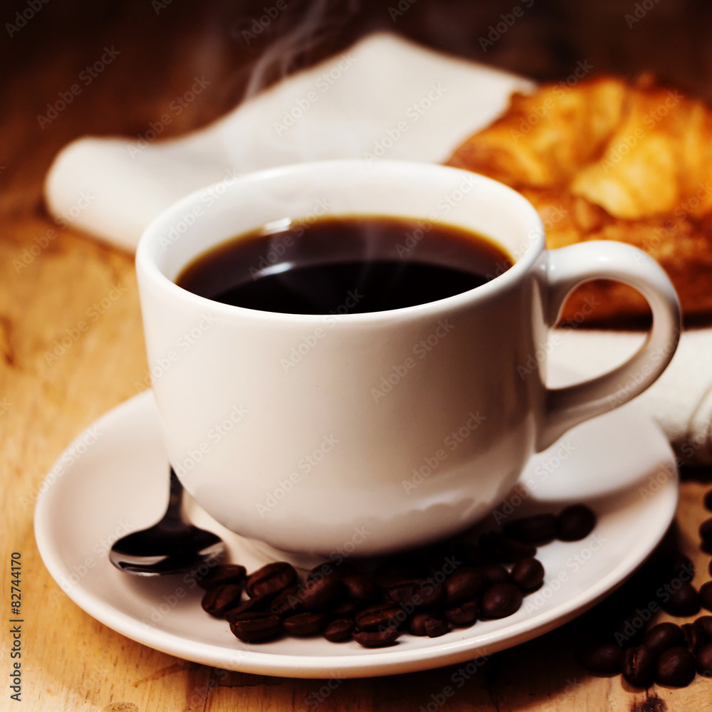 white cup of coffee,croissant and coffee bean on wooden table. ( white cup of coffee,croissant and coffee bean on wooden table. (