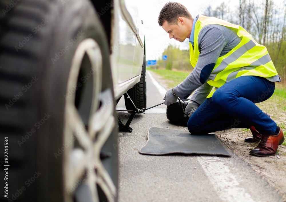 Man changing wheel on a roadside Man changing wheel on a roadside