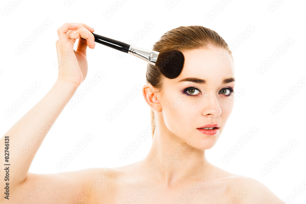 beautiful woman applying cosmetic with brush