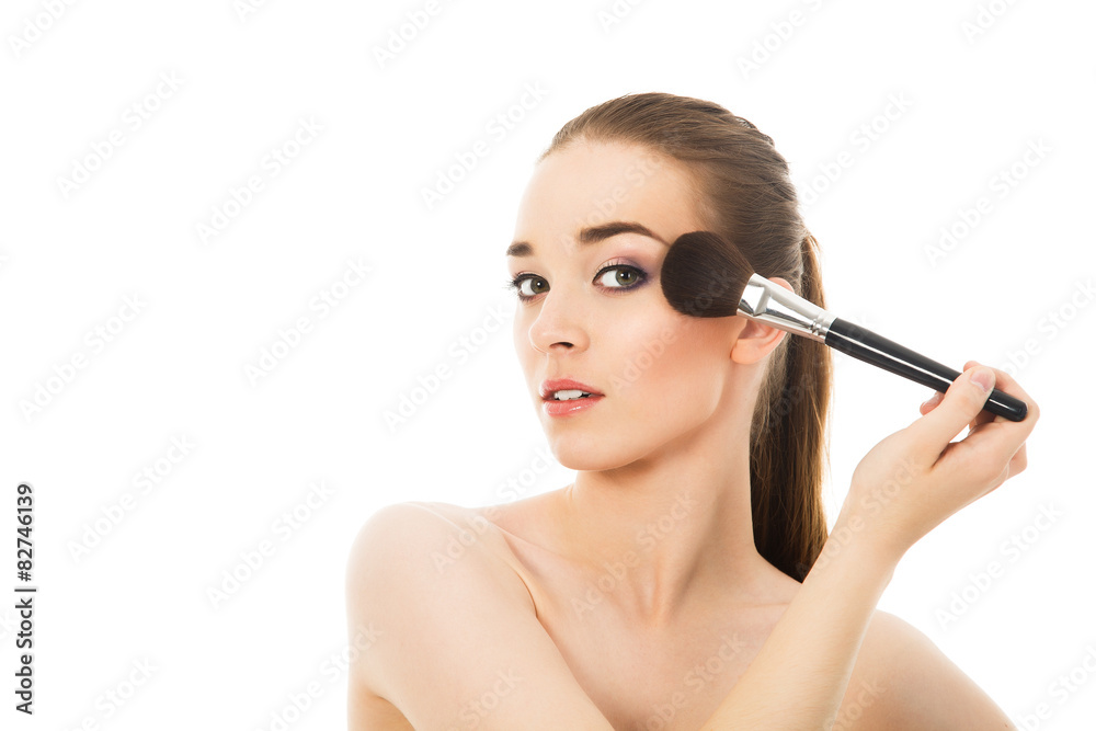 beautiful girl does make-up with brush