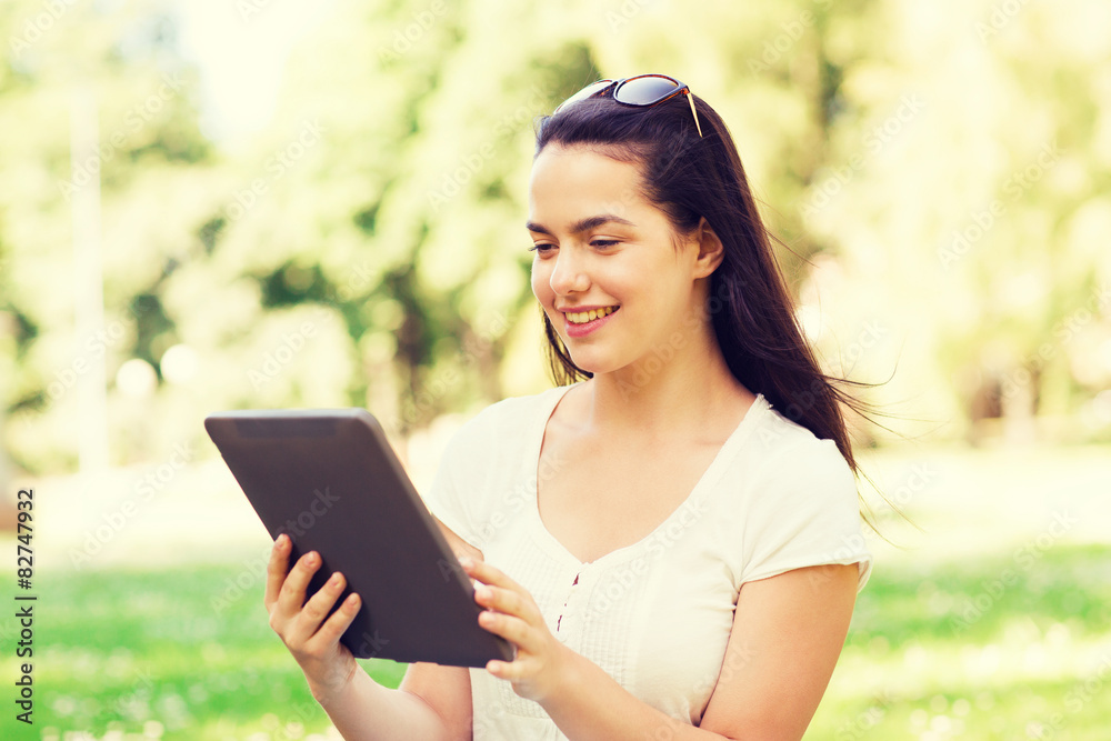 smiling young girl with tablet pc sitting on grass smiling young girl with tablet pc sitting on grass