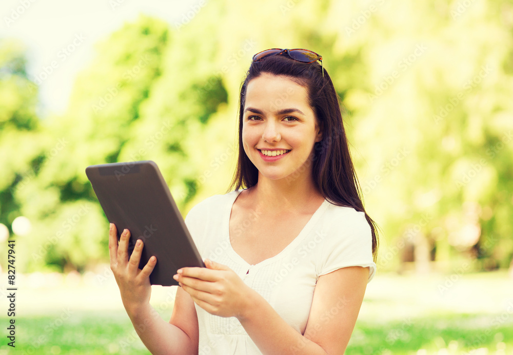 smiling young girl with tablet pc sitting on grass smiling young girl with tablet pc sitting on grass