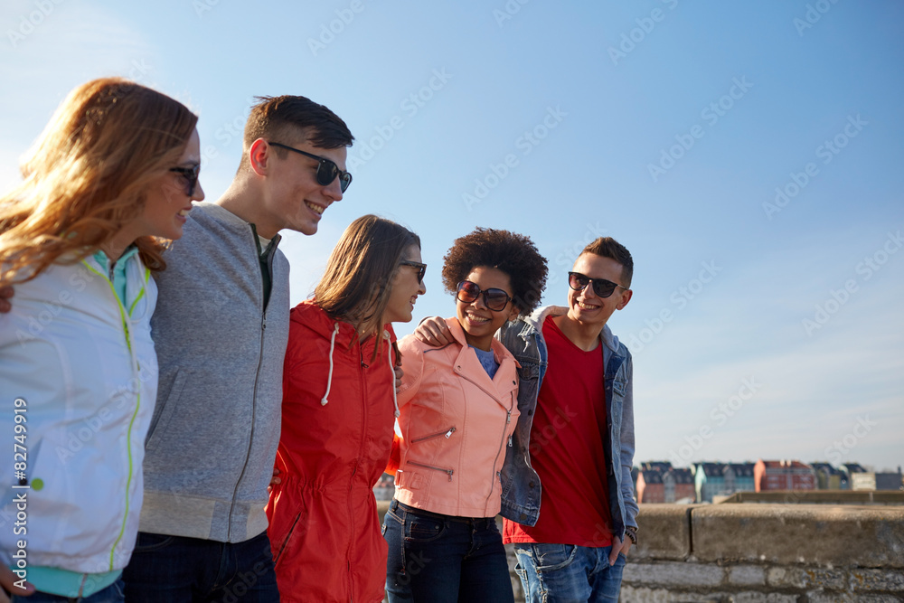 happy teenage friends walking along city street happy teenage friends walking along city street