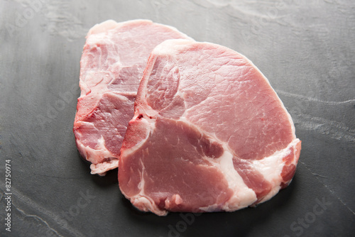 Top view raw pork chop on blackboard