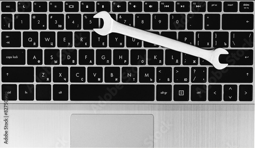 electronic technical support concept - spanners on computer