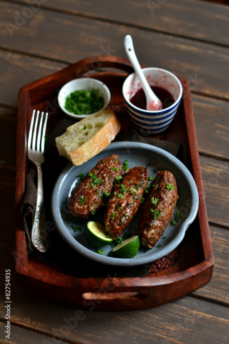 kebabs on wooden tray with cranberry sauce photo