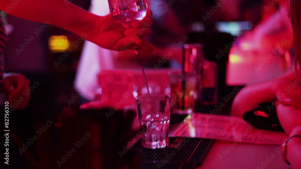 Barman working, pouring, serving alcohol drinks to bar guests