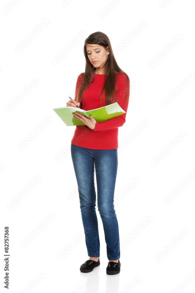 Young student woman writing in her note. Young student woman writing in her note.
