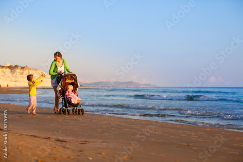 Mother with her daughter and baby on a sandy beach