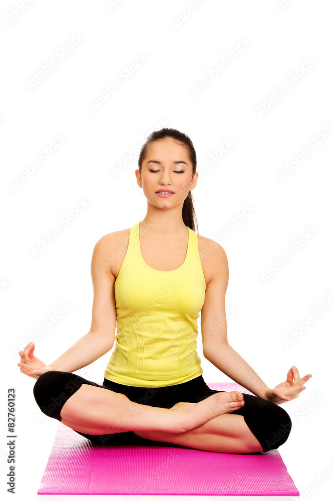 Slim female meditating in pose of lotus.