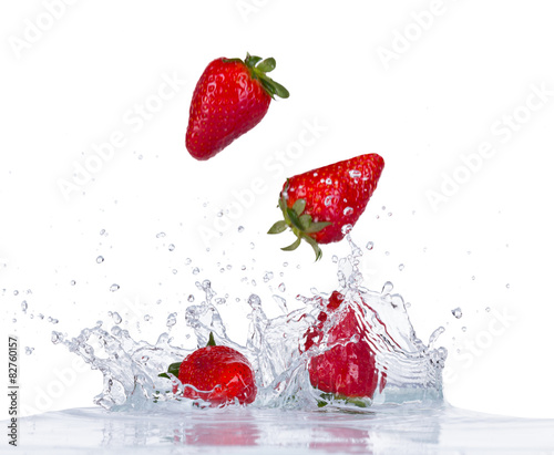 Fresh strawberries in water splash on white