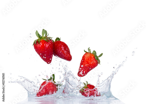 Fresh strawberries in water splash on white