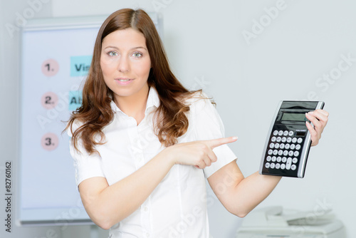 beautiful businesswoman pointing to the calculator