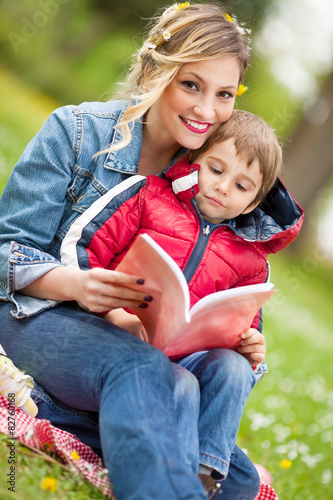 Young mother reading to her son in a park