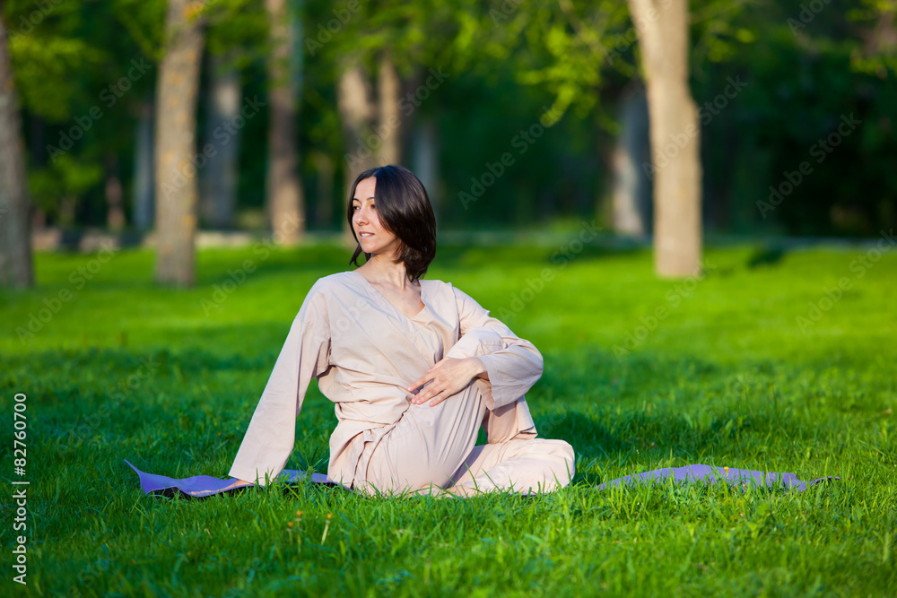 Practicing yoga in the morning, with trees background Practicing yoga in the morning, with trees background