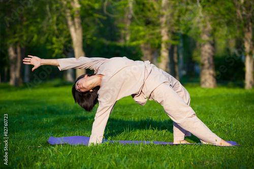 Practicing yoga in the morning, with trees background