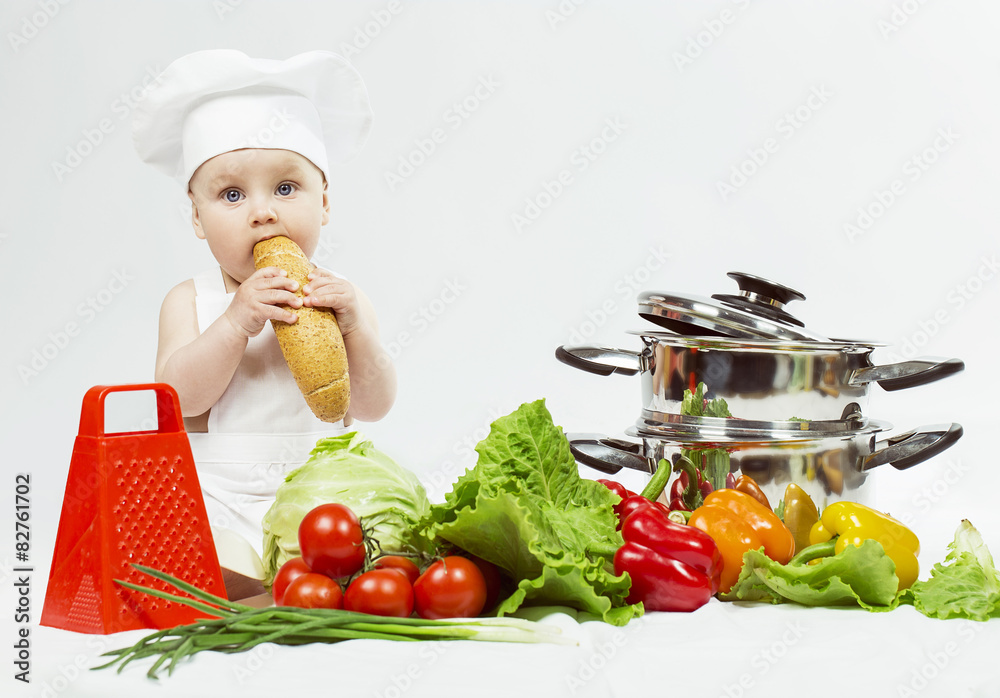 Little Chef boy preparing healthy food and eating a loaf of brea Little Chef boy preparing healthy food and eating a loaf of brea