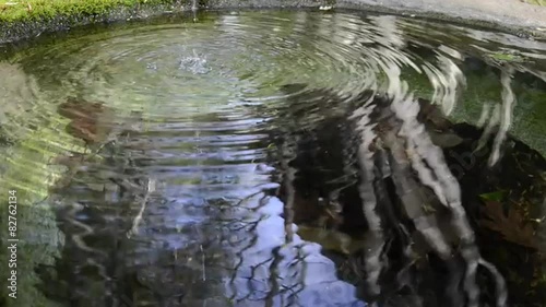 Looping trickle of water spills into a basin