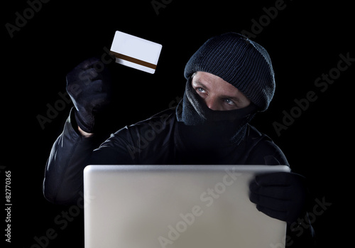 hacker man with credit card and computer in cyber crime concept