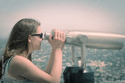 Young woman looking through coin binoculars
