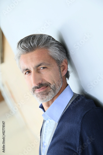 Portrait of smiling mature man standing in corridor