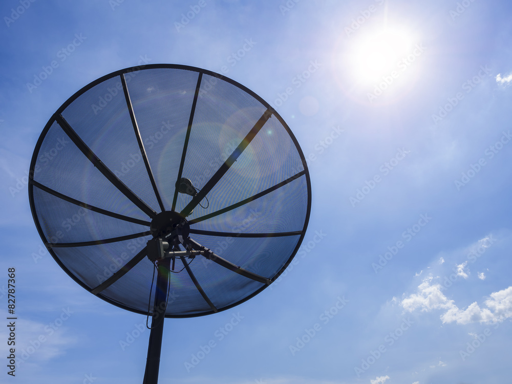 Satellite dish on blue sky background with sunlight