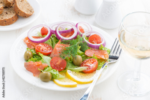 fresh salad with salted salmon on white wooden table